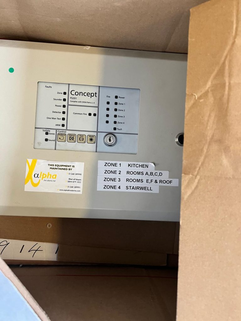 Faulty fire alarm control panel before replacement at an HMO in Bow E3